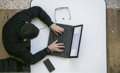 Un alumno con su portátil y su móvil en la Universidad Autónoma de Madrid.