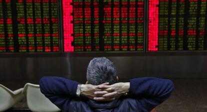 Un inversor chino observa una pantalla que muestra la evolución de los mercados financieros.