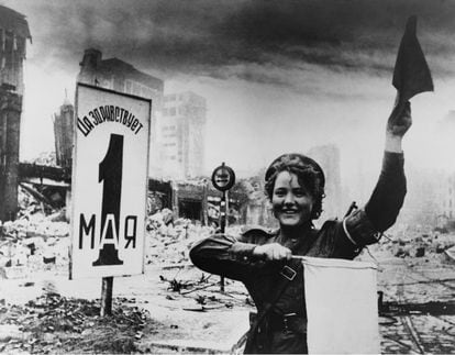 Maria Shalneva, una soldado soviética, en Berlín en 1945 delante de un cartel de celebración del Día del Trabajo.