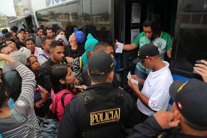 Inmigrantes venezolanos muestran sus documentos al subir a un autobús en la ciudad peruana de Tumbes, el pasado sábado.