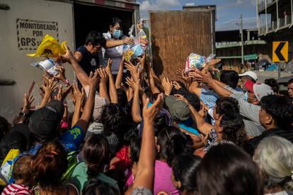 Damnificados por el huracán Iota se aglomeran ante un grupo de voluntarios que acudió a repartir alimentos. Cientos de familias se refugiaron debajo del puente Chamelecón en San Pedro Sula, Honduras, luego de que sus viviendas quedaran destruidas. Imagen del 25 de noviembre de 2020.