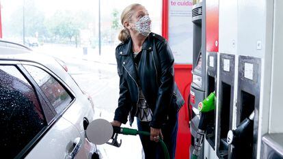 Una mujer reposta gasolina a su vehículo en Madrid, en junio.