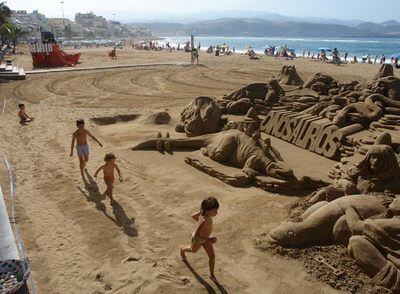 Esculturas de dinosaurios de arena en la playa de las Canteras, en Las Palmas de Gran Canaria.