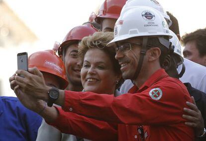 Dilma posa para fotos con trabajador de la Arena Corinthians.