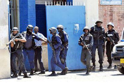 Varios miembros de las fuerzas de seguridad jamaicanas avanzan por las calles de Kingston, en busca del capo Dudus.