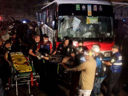 Los equipos de rescate transportan el cadáver de uno de los rehenes del autocar secuestrado por el ex oficial de policía en Manila, Rolando Mendoza.