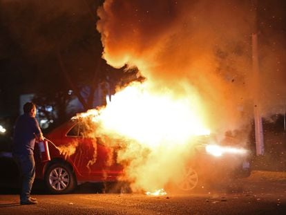 Agentes de policía apagan un coche incendiado en Zapopan, Estado de Jalisco, el 10 de agosto.