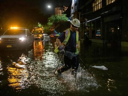 Un trabajador desbloquea los desagües en una calle afectada por las inundaciones en Brooklyn, Nueva York, a principios del 2 de septiembre de 2021, cuando las inundaciones repentinas y las lluvias récord traídas por los restos de la tormenta Ida barrieron el área.