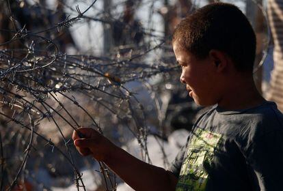 Un niño sirio desplazado de la provincia de Daraa huyendo de los bombardeos de las fuerzas progubernamentales, en un campamento improvisado para cruzar la frontera jordana, cerca de la ciudad de Nasib, en el sur de Siria.