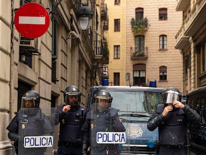 Policías nacionales se preparan para acordonar el paso de una manifestación.