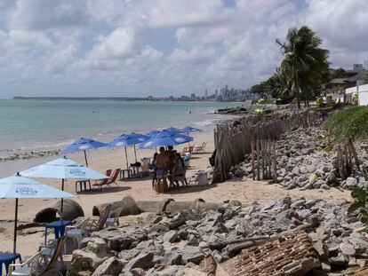 La playa de Bessa, en João Pessoa (Brasil), con la marea baja. Los diques y rompeolas que han construido para proteger las viviendas y locales se mezclan con las sombrillas.