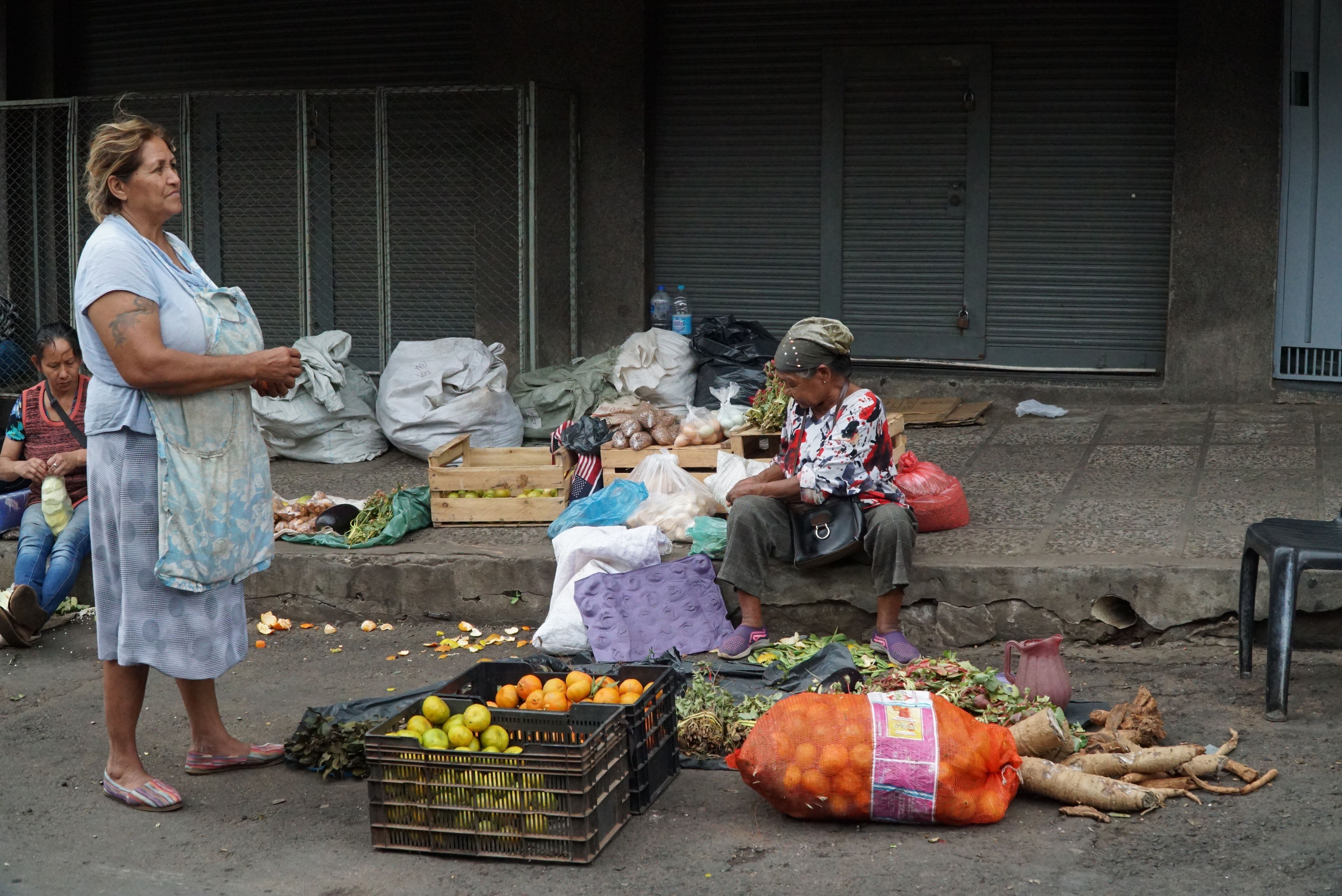 Dos mujeres venden hierbas y fruta en el Mercado 4 de Asunción.