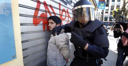 Un policía retiene a un estudiante en la protesta del lunes