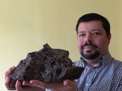 José María Madiedo, en su casa, sostiene uno de los meteoritos metálicos de su colección.