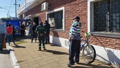Vecinos de Ensenada, en las afueras de Buenos Aires, hacen fila frente a un puesto de ventas de pastas instalado en el club Alumni.