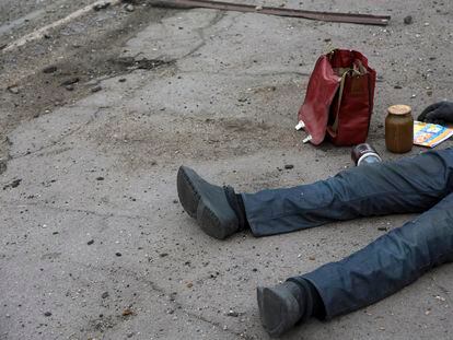 El cadáver de un civil yacía el sábado en el suelo en una parada de autobús cerca de una zona de combate en una planta metalúrgica en un área controlada por los separatistas prorrusos en Mariupol.