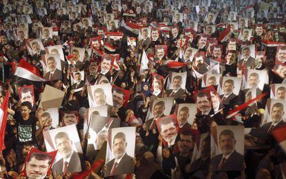 Partidarios del ex presidente Mohamed Mursi muestran fotos con su retrato para mostrar su disconformidad ante la decisión del ejercito de expulsarlo del gobierno.