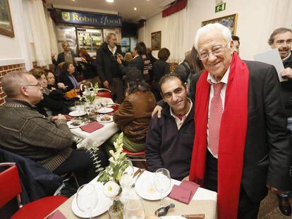 El padre Ángel con varias personas en su restaurante.