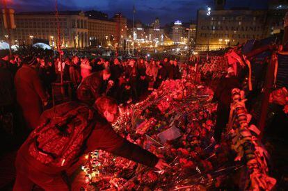 Ciudadanos ucranios dejan velas y flores en homenaje a los muertos durante las protestas del Maid&aacute;n.  