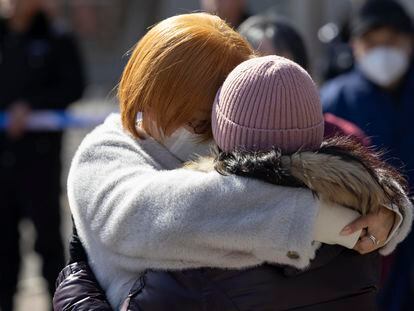 Dos familiares de los pasajeros del MH370 de Malaysia Airlines se abrazaban este viernes durante una concentración junto a la Embajada malasia en Pekín (China).