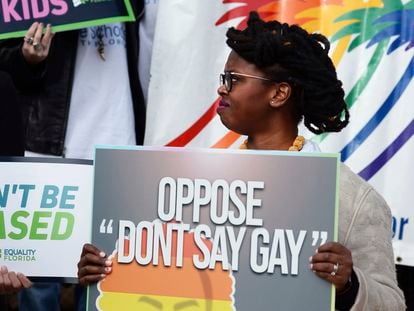 Ebonni Chrispin de AIDS Healthcare Foundation sostiene un cartel en contra de la ley durante una conferencia de prensa, el 15 de febrero de 2022.