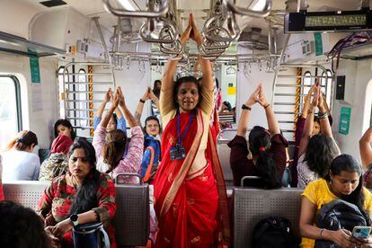 Un grupo de mujeres practica yoga en un tren con motivo del Día Internacional de la Mujer en Bombay (India).