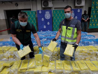 Un miembro de la UDYCO (d) y otro de la UCO (i) muestran los 3.800 kilos de cocaina incautados en el puerto de Valencia en una operación conjunta de la Policía Nacional y la Guardia Civil.