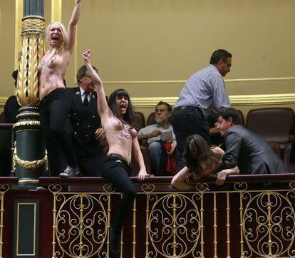 Las activistas llevaban en el pecho la misma frase que han gritado: "El aborto es sagrado". En la imagen, un ujier alcanza a Lara Alcázar, la líder de Femen en España.