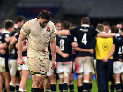 LOs jugadores escoceses celebran el triunfo en Twickenham, con un desolado Jonny Hill en primer término