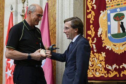 El alcalde de Madrid, José Luis Martínez-Almeida, entregó uno de los galardones al bombero Ángel Martín Recio, jefe de Grupo Conductor en Apoyo Técnico, durante la ceremonia de entrega en el Patio de Cristales de la Casa de la Villa.