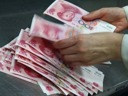 Una empleada de un banco en Corea del Sur cuenta billetes de yuan.