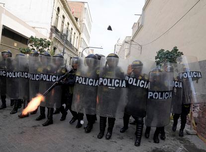 Un policía antidisturbios dispara su arma para dispersar a los manifestantes.