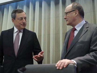 Al la izquierda, el presidente del Banco Central Europeo, Mario Draghi, conversa con el gobernador del Banco de España, Luis Linde