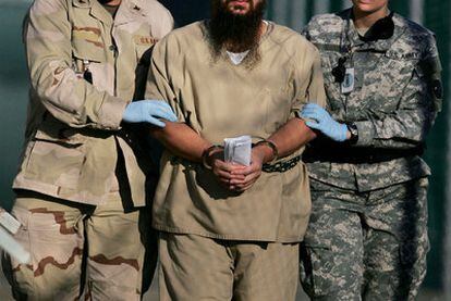 Dos soldados conducen a un preso esposado en el penal de Guantánamo en 2006.