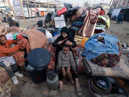 Una joven palestina peinaba a su hermana junto a todas sus pertenencias en una calle de Rafah, este martes.