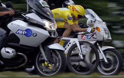 Alberto Contador, con el maillot amarillo pedalea entre dos motos durante la contrareloj de Annecy. en la 18ª etapa del Tour de Francia, en 2009.