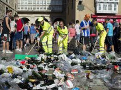 Trabajadores y voluntarios recogen botellas y desechos en Vitoria. 