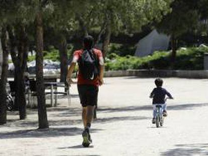 Un hombre hace deporte con un niño en bicicleta.