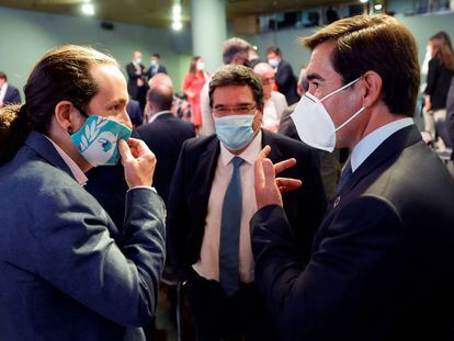 Iglesias conversa con el presidente del BBVA, Carlos Torres, junto con el ministro de Seguridad Social, José María Escrivá,  este lunes en Madrid.