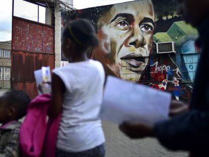 Personas caminan en Nairobi frente a un graffiti de Obama.