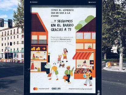 Marquesina informativa con publicidad de Mastercard en una calle de Madrid.