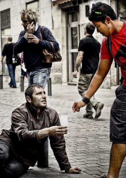 Un turista da limosna a un mendigo en Madrid.