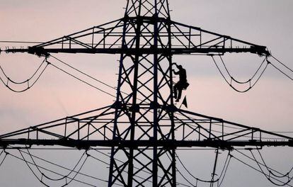 Un treballador dalt d'una torre elèctrica.