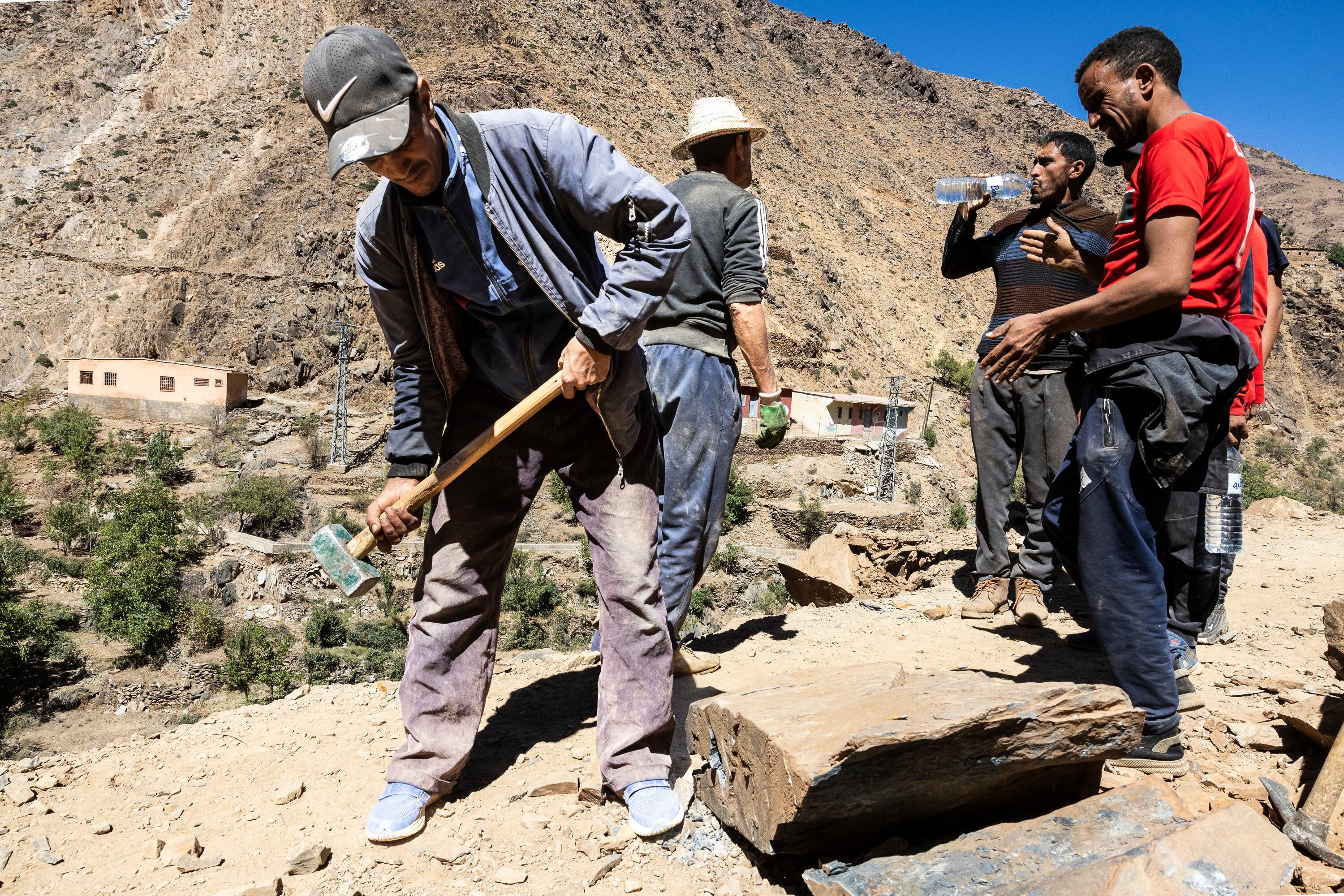 Los hombres se encargan de reconstruir la pista con las rocas desprendidas. 