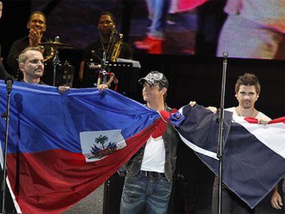 Milly Quezada, Miguel Bosé, Alejandro Sanz, Juanes, Luis Fonsi y Juan Luis Guerra sostienen la bandera de Haití y de la República Dominicana al final del concierto.