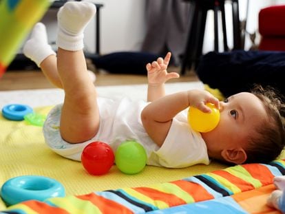 Una bebé juega con unas pelotas.