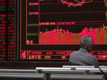 Un hombre contempla un monitor con cotizaciones bursátiles en una casa de corretaje de acciones de Pekín.
