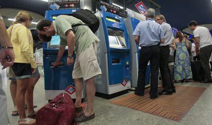 Viajeros de metro compran billetes en una estación de Madrid.