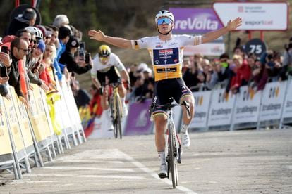 Evenepoel alza los brazos antes de cruzar la línea de meta de La Molina por delante de Roglic.