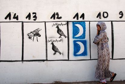 Una mujer pasa en Rabat ante dibujos de propaganda electoral en vísperas de las municipales de junio de 2009 en Marruecos